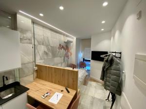 a room with a desk and a sink and a bedroom at AIRVA: Apartamentos Bajada de la Libertad in Valladolid