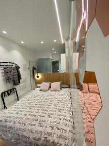 1 dormitorio con 1 cama grande con almohadas rosas en AIRVA: Apartamentos Bajada de la Libertad, en Valladolid