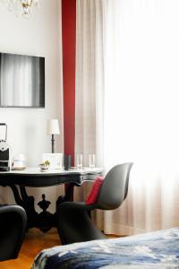 ヴィシーにあるMaison Decoret - Relais & Châteauxのテーブルと椅子、窓が備わる客室です。