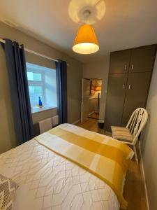 a bedroom with a bed and a chair and a window at Sandpit Cottage in Browns Cross Roads