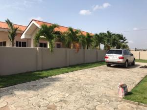 ein Auto, das in einer Einfahrt vor einem Haus geparkt ist in der Unterkunft AGASTEV Guesthouse GH in Accra