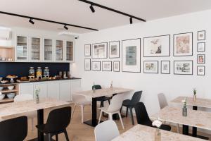 een restaurant met tafels en stoelen en foto's aan de muur bij Boutique Hotel HOH in Zagreb