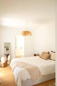a white bedroom with a large bed and a lamp at Casas do Forte Wood 6pax Piscina Privativa by Portugal Hideaway in Tavira +26 photos