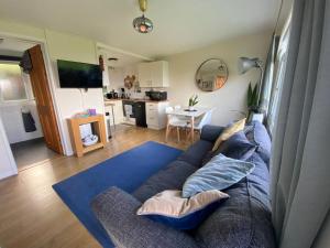 a living room with a blue couch and a kitchen at 27 Sea Valley Chalet in Bucks Mills
