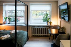 1 Schlafzimmer mit einem Bett, einem Schreibtisch und 2 Fenstern in der Unterkunft City Center Unique Boutique Apartment in Hamburg