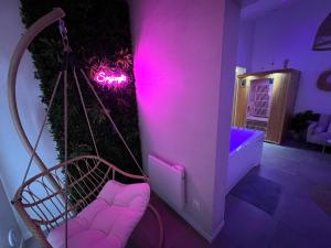 a room with a swing and a neon sign at SPA JUNGLE in Le Mesnil-Saint-Denis