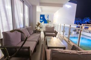 Maho Beach Hideaway Lux 1BR next to The Morgan Resort في Maho Reef: غرفة معيشة مع كنب وشرفة مع مسبح