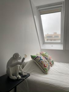 a monkey sitting on top of a bed with a lamp at Moderne studio in Nieuwpoort