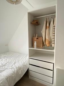 a bedroom with a bed and a white closet at Moderne studio in Nieuwpoort