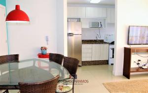 uma cozinha e sala de jantar com uma mesa de vidro em 1007 Residencial Fontini Apto 302 - Praia de Bombas em Bombinhas