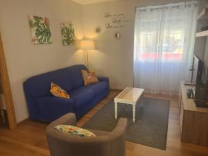 a living room with a blue couch and a table at CASA Campelo - Playas de Pinténs - HIO - Ría de Aldán - CANGAS in Hio