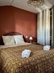 1 dormitorio con 1 cama con 2 toallas en Maison au Jude en Lamothe-Landerron