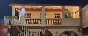 a house with a balcony with a flag on it at Yellow-Gray Tropical Studio in San Juan