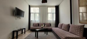 uma sala de estar com dois sofás e uma televisão em Appartement idéal pour découvrir la ville em Rabat