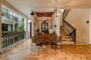 una casa con 2 sillas y una escalera en Hotel Banana Boutique & Spa by Paradise Hotels - 5th Av Playa del Carmen, en Playa del Carmen