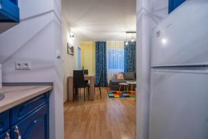 a kitchen with a refrigerator and a living room at Calendula apartments in Tuzla