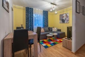 a living room with a couch and a table at Calendula apartments in Tuzla