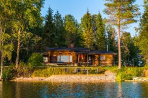 a cabin in the woods next to a body of water at Suvituuli in Kuusamo