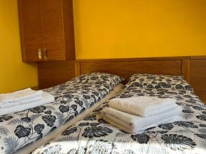 1 dormitorio con 1 cama con toallas en Apartment Vila Marianna en Tatranská Polianka