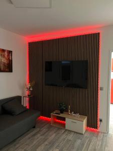 - un salon avec un canapé et des lumières LED rouges dans l'établissement Gartenparadies mit Rheinblick in Urbar, à Urbar