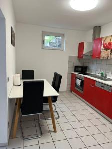 een keuken met rode kasten en een tafel en stoelen bij Gartenparadies mit Rheinblick in Urbar in Urbar