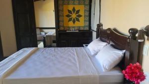 a bedroom with a large bed with white sheets and pillows at Barbanera Club & Hotel de Charme in Caucaia