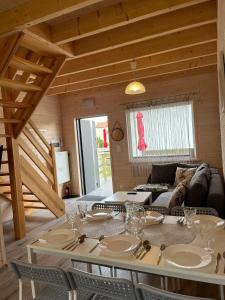 a dining room with a table and chairs in a room at Domki Słoneczka in Sarbinowo