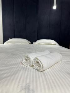 two towels are laying on a white bed at мини-отель Villa Sofia город Шымкент, проспект Тауке хана, жилой дом 37-2 этаж in Shymkent
