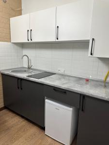 a kitchen with white cabinets and a sink at мини-отель Villa Sofia город Шымкент, проспект Тауке хана, жилой дом 37-2 этаж in Shymkent