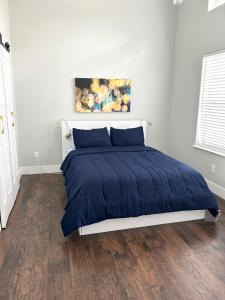 1 cama con edredón azul en un dormitorio en Joys Galleria Luxury Homes, en Houston