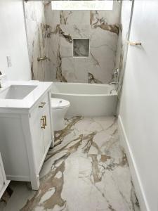 a bathroom with a sink and a tub and a toilet at Joys Galleria Luxury Homes in Houston