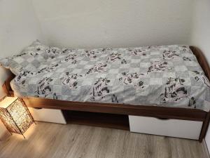 a bed with a quilt on it with a lamp at Ferienhaus Susanne in Heinsberg