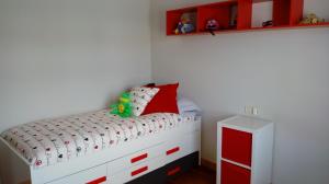 um quarto para crianças com uma cama e armários vermelhos e brancos em Casa Chocolate San Miguel del Pino Valladolid em San Miguel del Pino