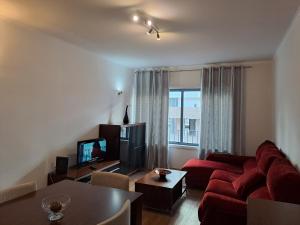 a living room with a red couch and a television at Parque das Nações in Lisbon