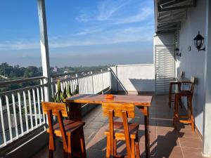 a wooden table and chairs on a balcony at NVD12A #notrevilladagonvd for 10pax in Bandung
