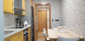 a kitchen with a table and a dining room at Apartamento Sabaris Playa in Baiona