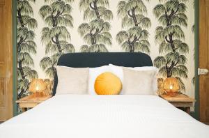 a bedroom with a bed with a white bedspread and palm tree wallpaper at Hamilton House in Sheffield