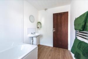 a bathroom with a sink and a wooden door at South Street Apartments in Derby