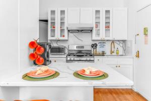布魯克林的住宿－Welcome to “Sunny Park Slope Retreat”!，一间白色的厨房,柜台上放着两盘食物