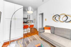 a living room with a couch and a kitchen at Welcome to “Sunny Park Slope Retreat”! in Brooklyn