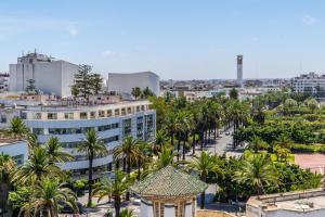 JM Suites Hotel Eco-Friendly Casablanca في الدار البيضاء: اطلالة على مدينة فيها نخل ومباني