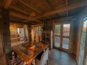 a dining room with a wooden table in a cabin at Pousada Vale da Magia in Praia do Rosa