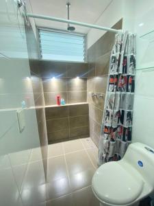 ein Bad mit einer Dusche, einem WC und einem Duschvorhang in der Unterkunft Disfruta hermoso apartaestudio in Ricaurte
