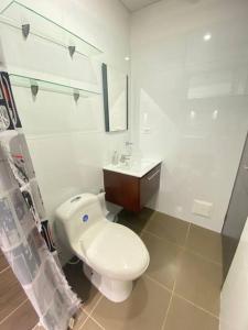 ein weißes Bad mit einem WC und einem Waschbecken in der Unterkunft Disfruta hermoso apartaestudio in Ricaurte