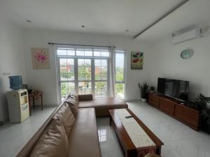 sala de estar con sofá y TV en NVD12A #notrevilladagonvd for 10pax en Bandung