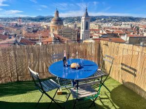 - une table avec une bouteille de vin au sommet d'une ville dans l'établissement Triplex Toit-Terrasse Authentique Vieux-Nice & Mer, à Nice