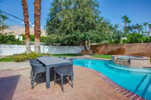a patio with a table and chairs next to a pool at Close to downtown PS - Hike, Bike, Swim, Relax in Palm Springs
