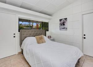 um quarto com uma cama branca e uma almofada em Close to downtown PS - Hike, Bike, Swim, Relax em Palm Springs