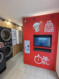 uma máquina vermelha numa lavandaria com um micro-ondas em Andemu Studio cabine 2 à 4 personnes Barèges em Barèges
