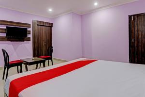 Habitación de hotel con cama, mesa y sillas en Flagship VENTURE INN GUEST HOUSE, en Bhubaneshwar